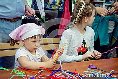 Charity Family festival â€“ small girls participating at art and craft outdoor workshop Editorial Stock Photo